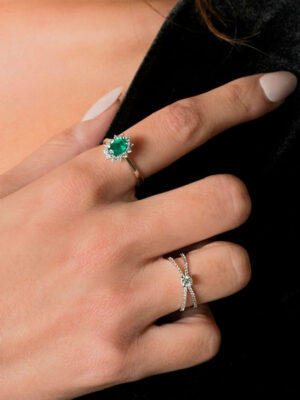 Anillo de oro blanco con esmeralda central rodeada de diamantes